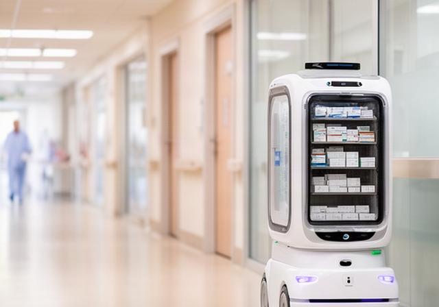 Robot mobile bianco che trasporta farmaci in un corridoio ospedaliero luminoso